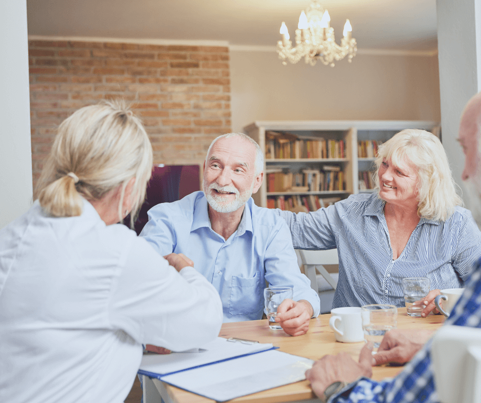 two seniors, white hair, blue shirts, meeting with a doctor in a white coat